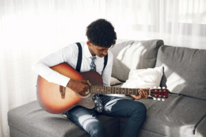 know-your-why-young-man-tights-sitting-living-room-musician-playing-guitar