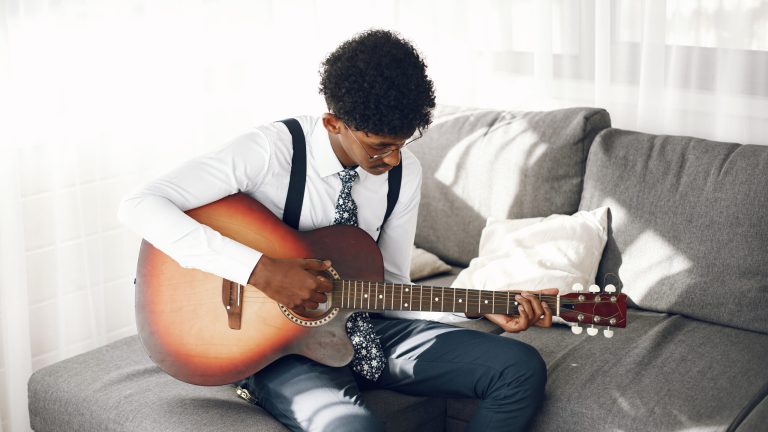 know-your-why-young-man-tights-sitting-living-room-musician-playing-guitar